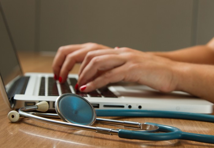 doctor typing on computer