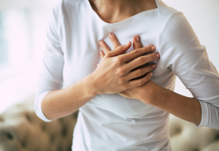 a woman clutching her chest in pain