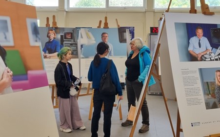 two people are talking to each other surrounded by the displayed pictures