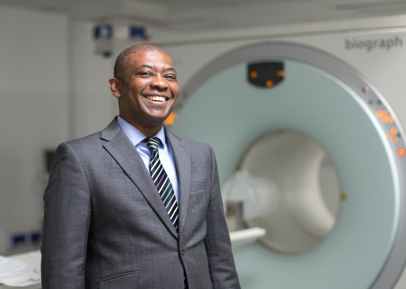 Professor Eric Aboagye standing in front of a PET scanner